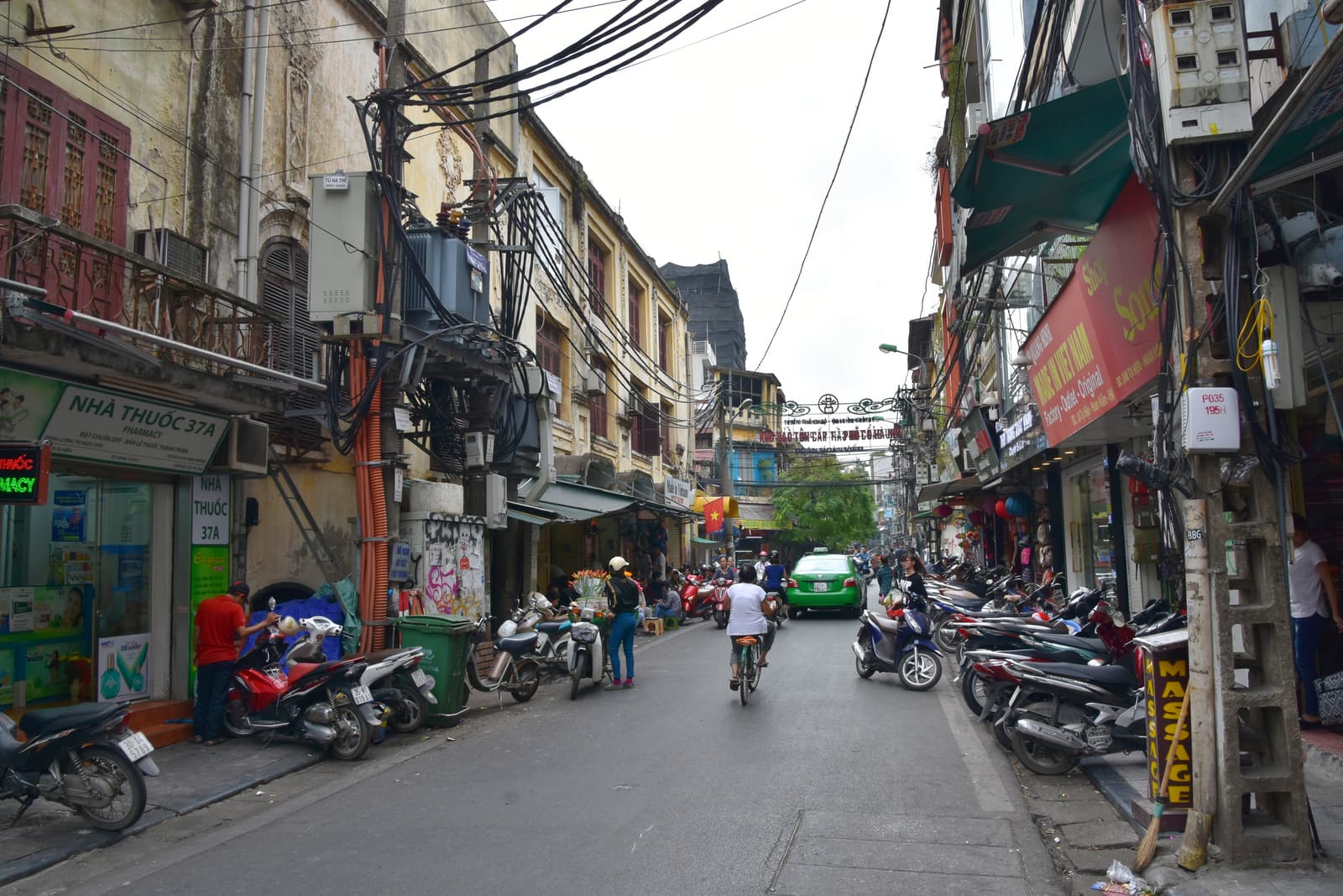 Shophouses, signs and motorbikes on a street in the Old Quarter