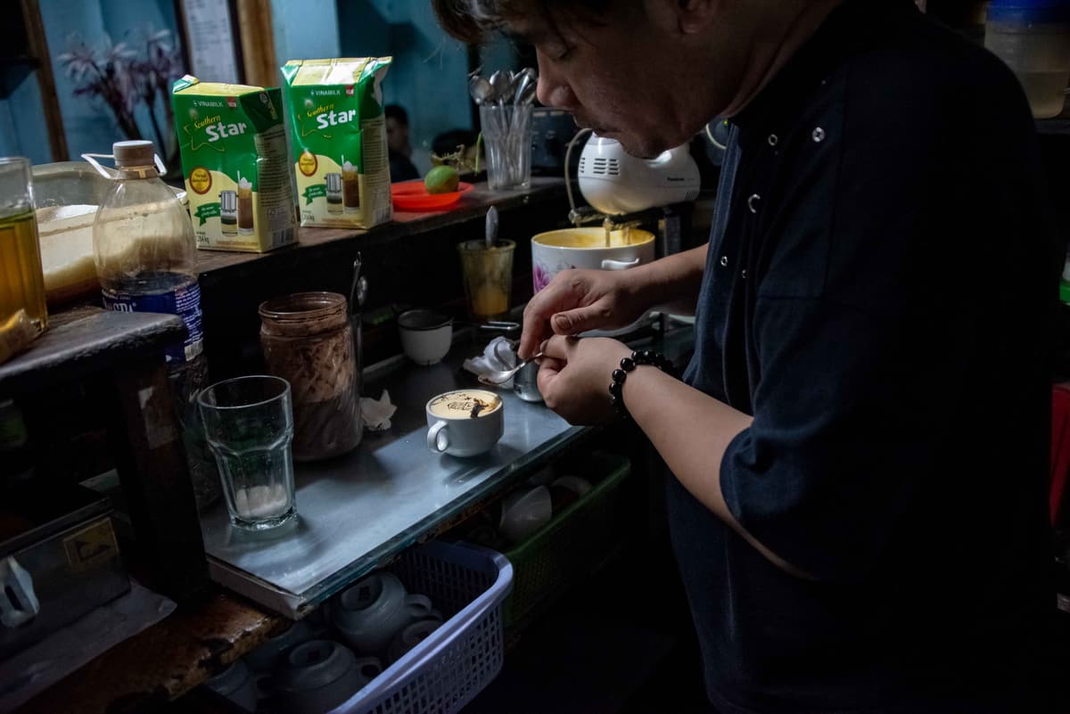 A barista preparing egg coffee in a Hanoi café