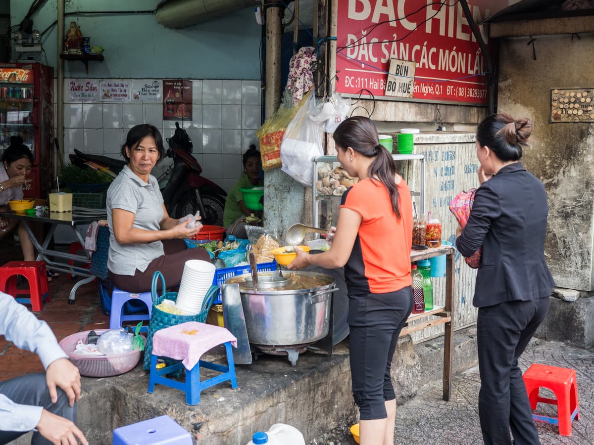 Diners on low plastic stools at a street food stall in Hanoi’s Old Quarter